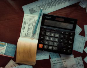 Taschenrechner mit Finanzunterlagen auf Schreibtisch – Symbol für steigende PKV-Beiträge und Kostenkontrolle